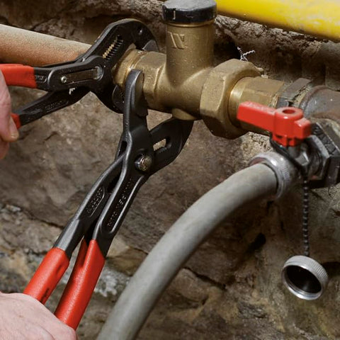 KNIPEX Cobra 12-inch red pliers in use on a pipe