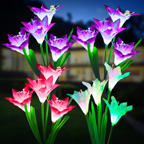 KOOPER outdoor solar lights with bigger lily flowers illuminate a garden at night.