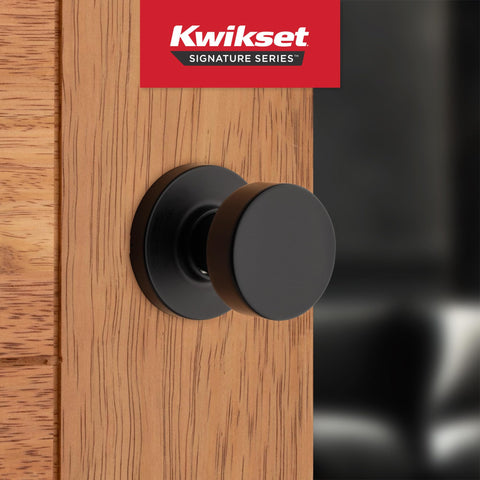 Kwikset Pismo matte black round rose highlights contemporary interior styling.