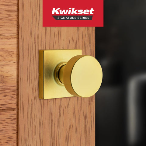 Kwikset Pismo satin brass finish close-up showing textured surface.