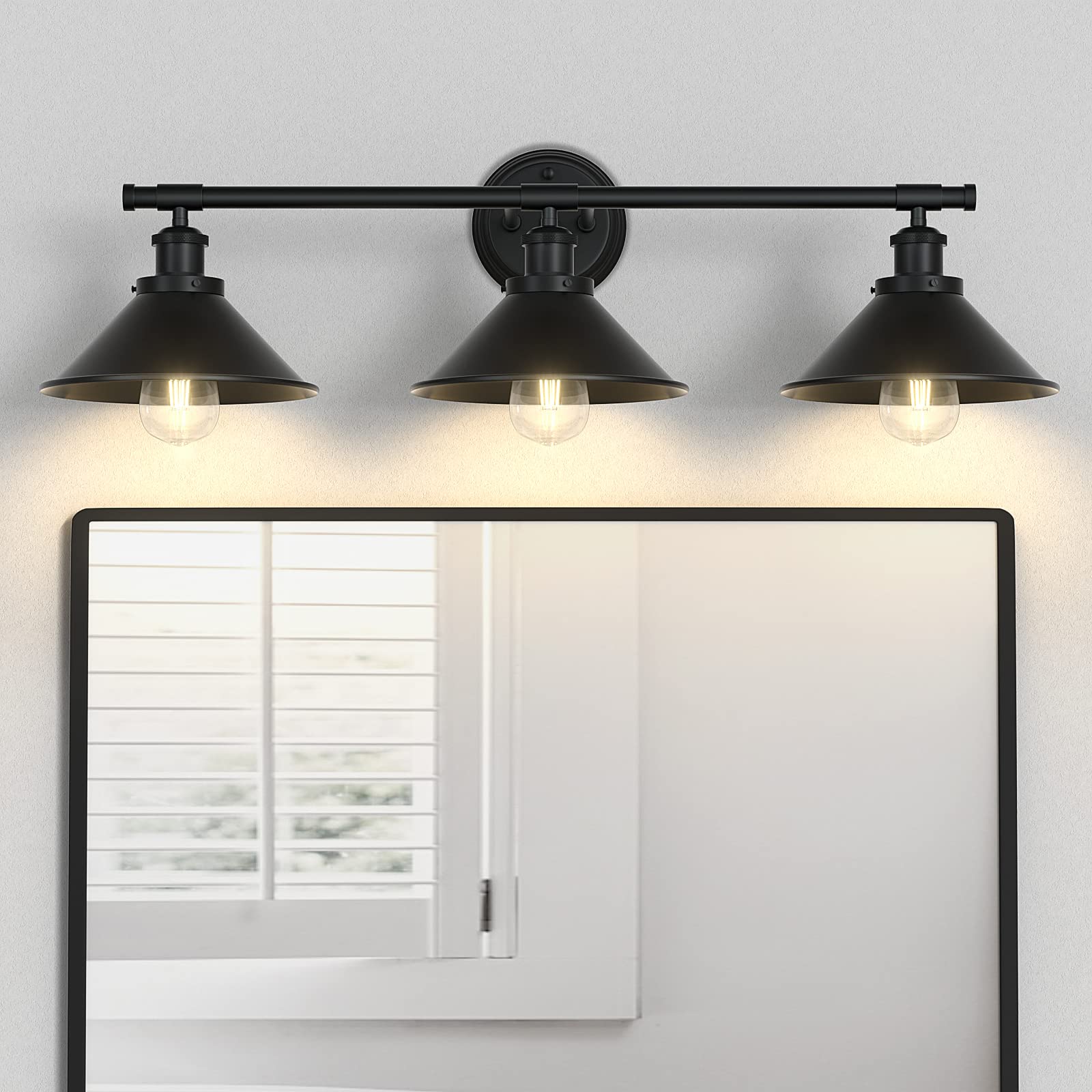 Licperron 3-light black vanity light with matte metal shade over a bathroom mirror.