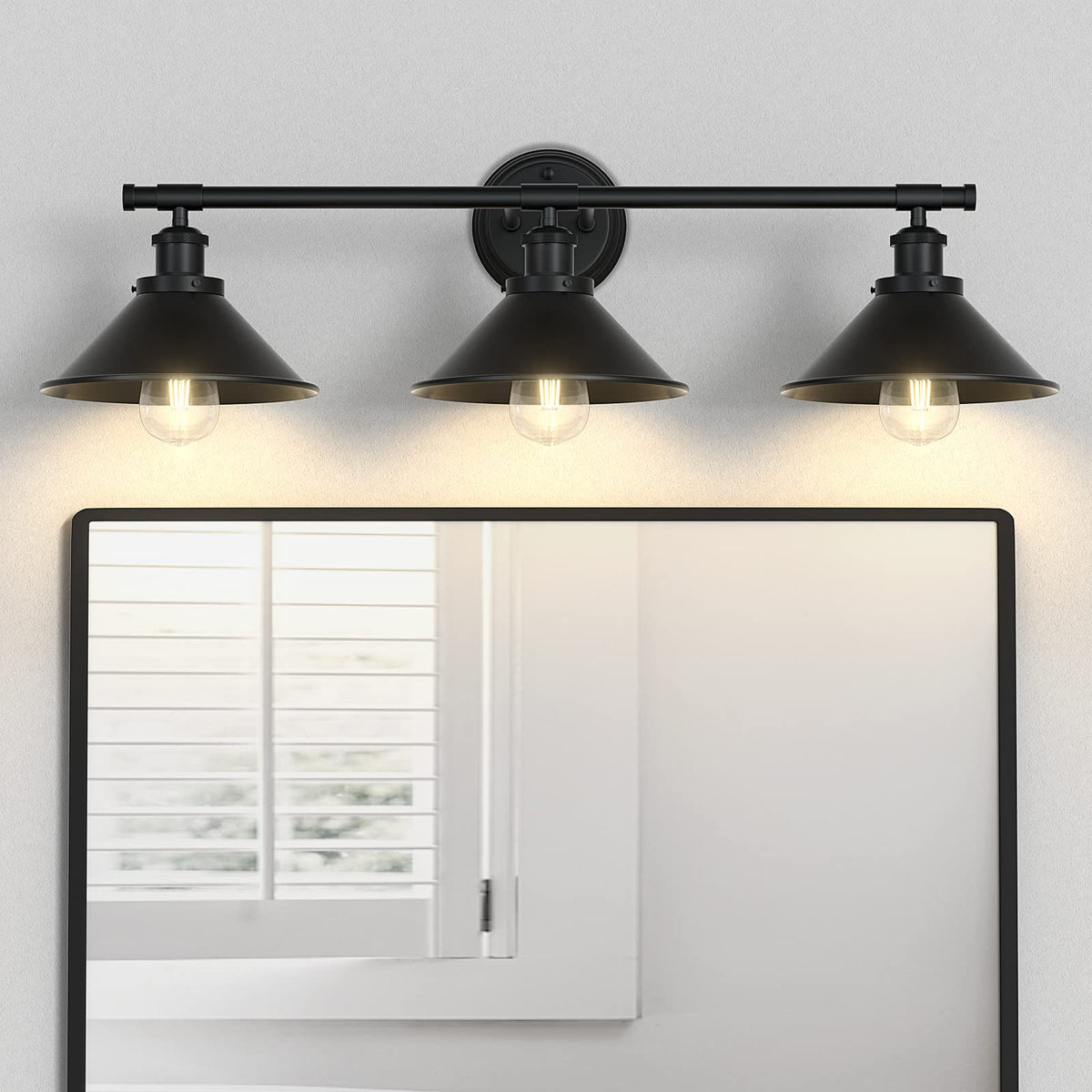 Licperron 3-light black vanity light with matte metal shade over a bathroom mirror.