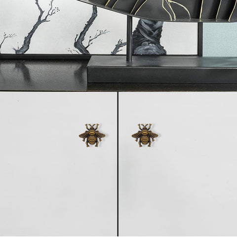 Antique dresser with bee knobs for vintage style.