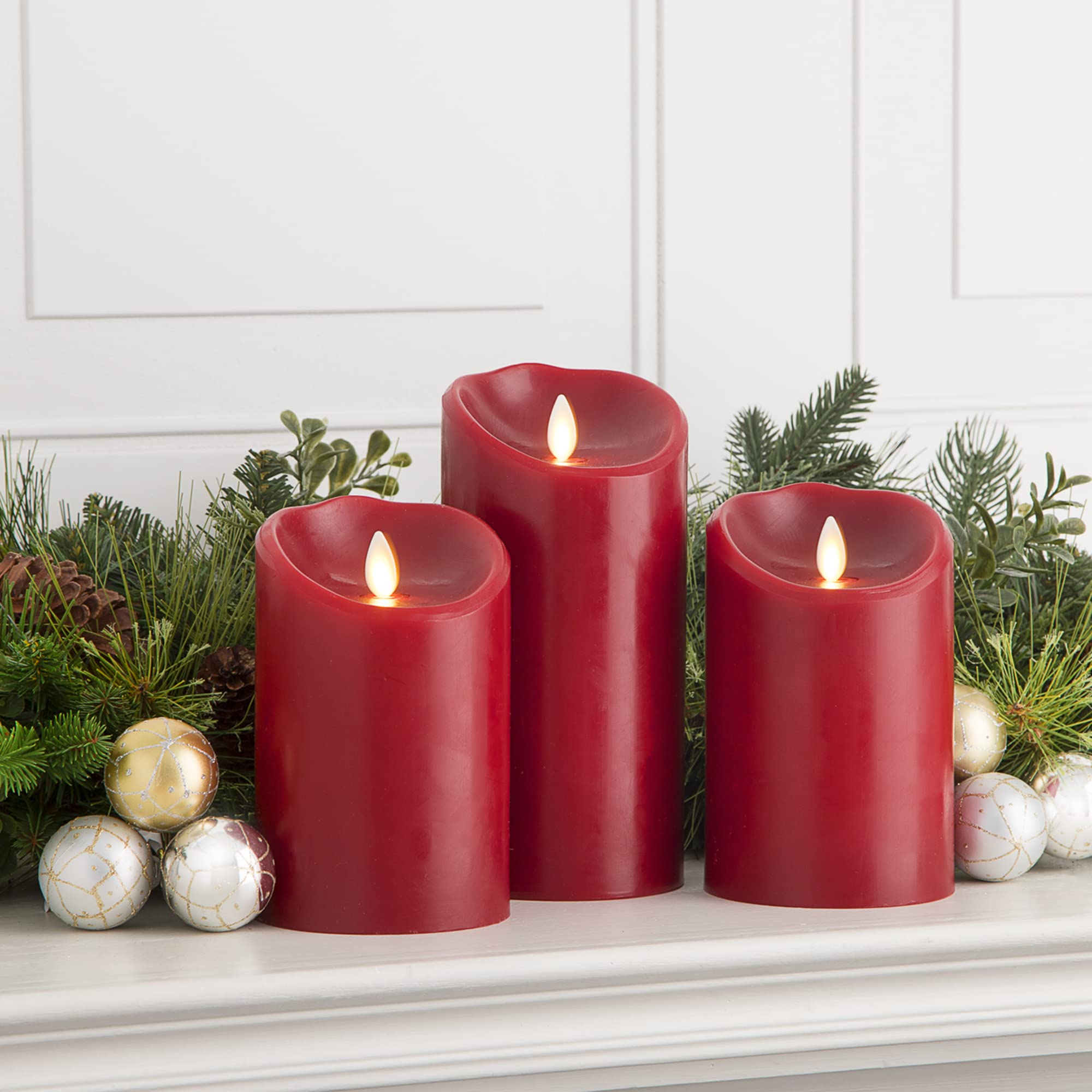 Luminara Burgundy flameless candle 3x5 glowing softly on a festive table