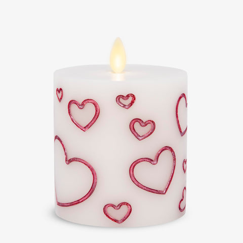 Luminara Debossed Hearts Pillar Magenta closeup showing textured hearts and warm glow
