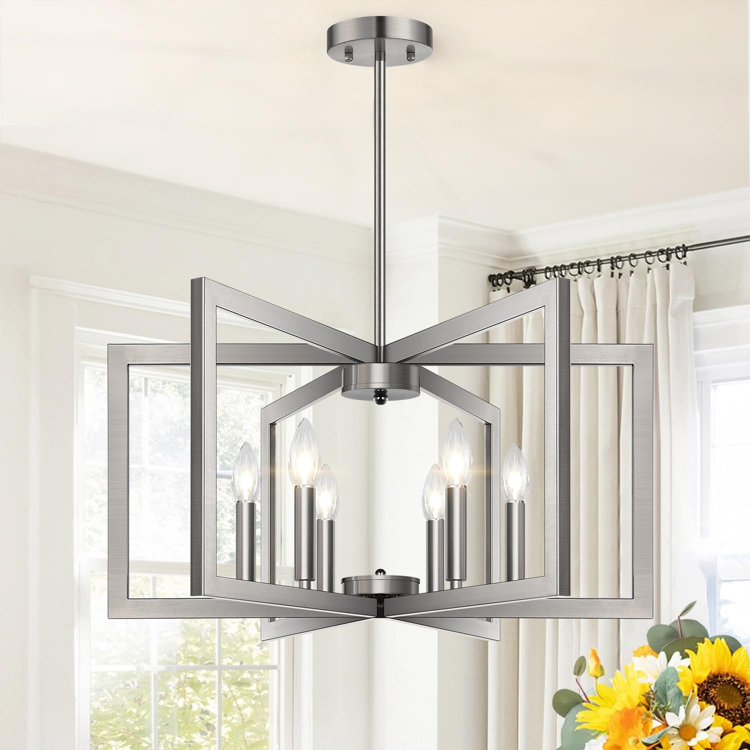 Lynnoland 25-inch brushed nickel chandelier over table for modern dining ambience.