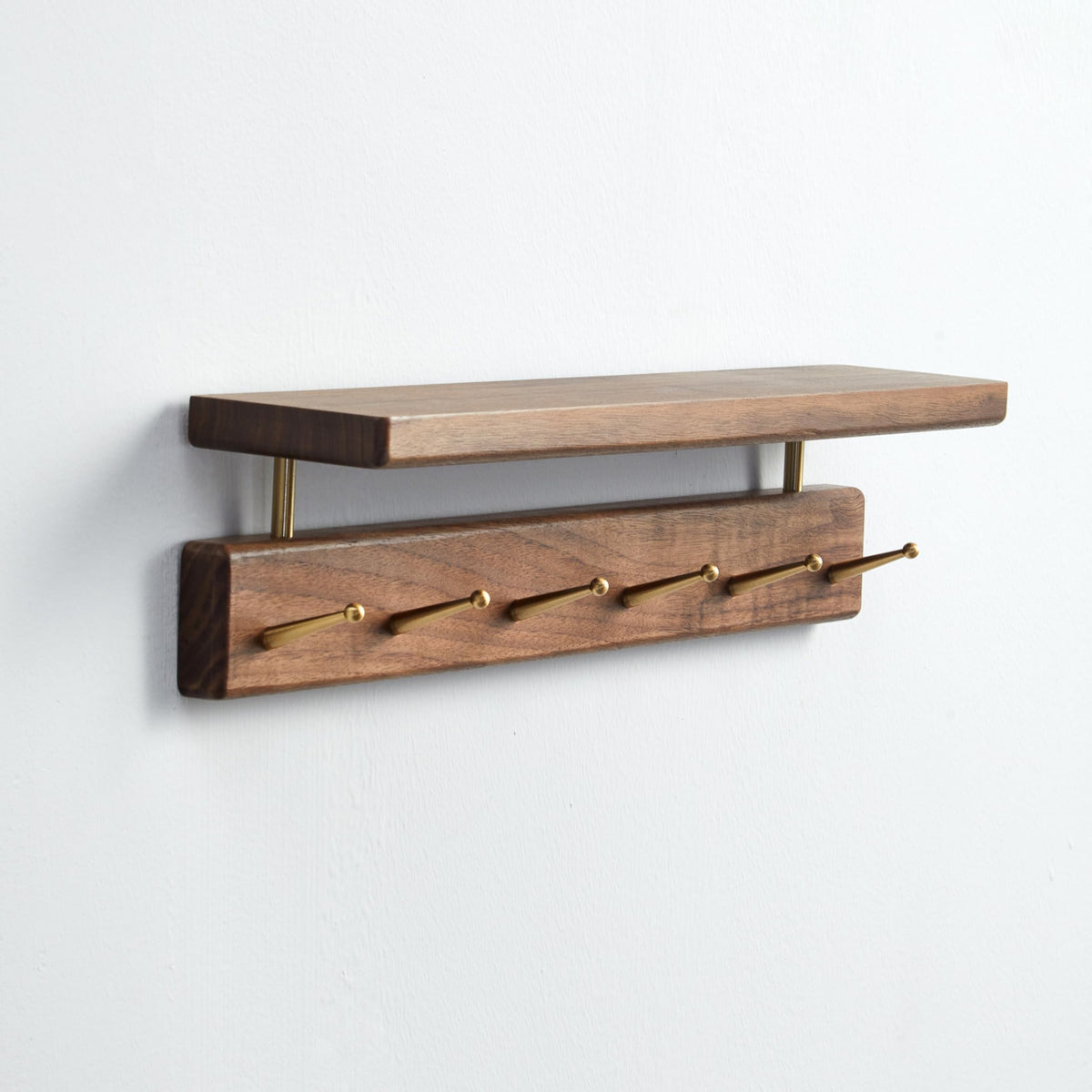 Mayhas solid wood shelf with walnut finish and hooks for coats and bags.