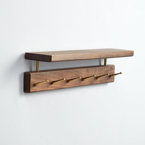 Mayhas solid wood shelf with walnut finish and hooks for coats and bags.