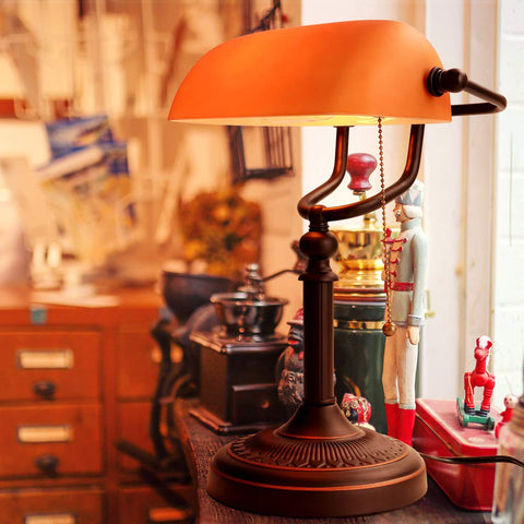 Newrays matted orange glass bankers lamp close-up shows sturdy glass shade and pull chain.