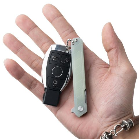 OLITANS G046 Mecha Mini shows one-handed operation for quick blade access.