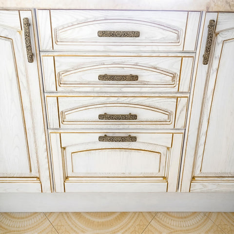 Otoolling hand-painted details provide a glossy vintage look on cabinet pulls.