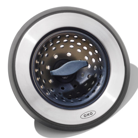 OXO Good Grips 2-in-1 sink strainer stopper in use traps debris while filling or draining.