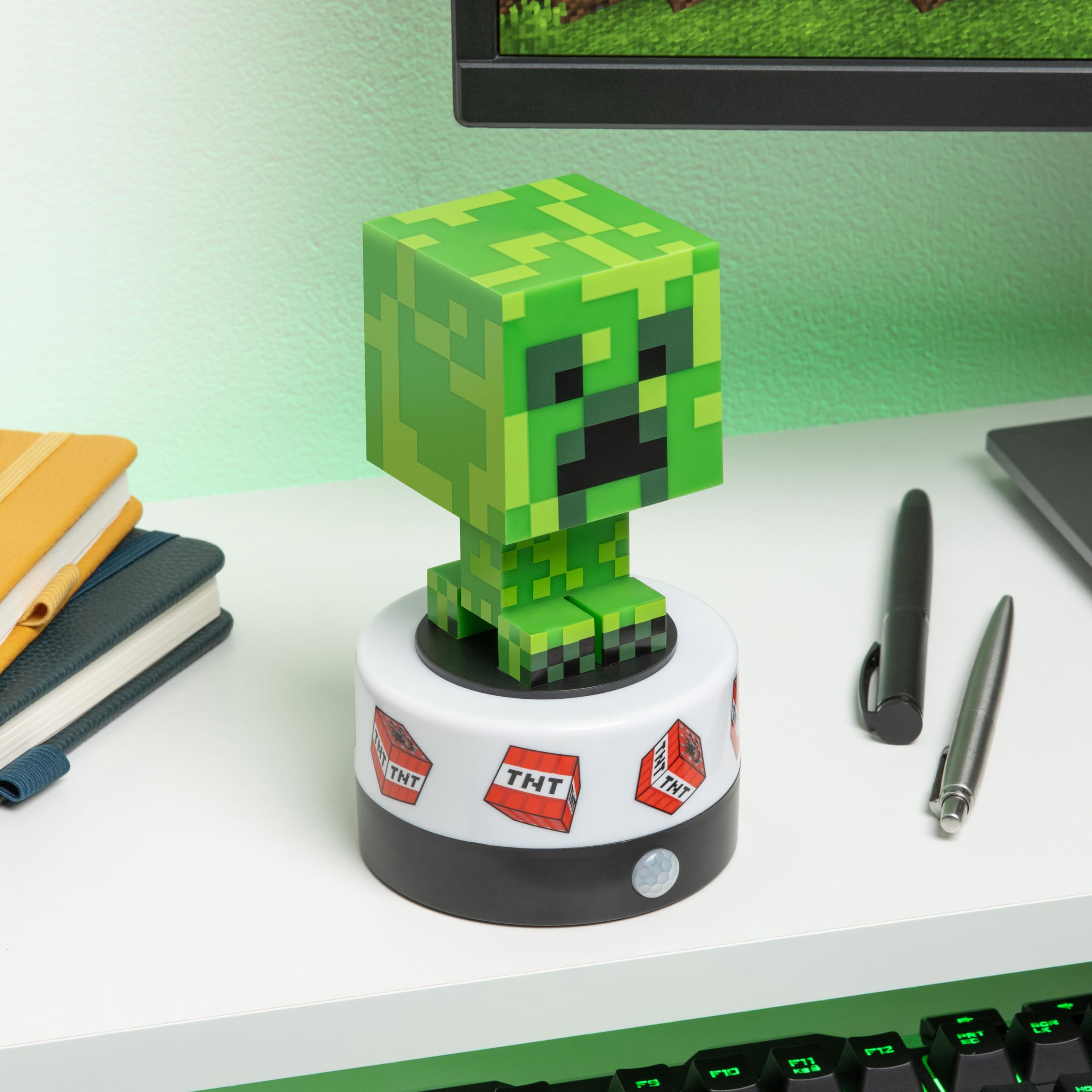 Paladone Minecraft Creeper night light emits a soft green glow for reading.
