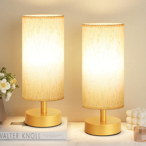 PartageiZ small table lamp in gold on a nightstand with warm ambient light