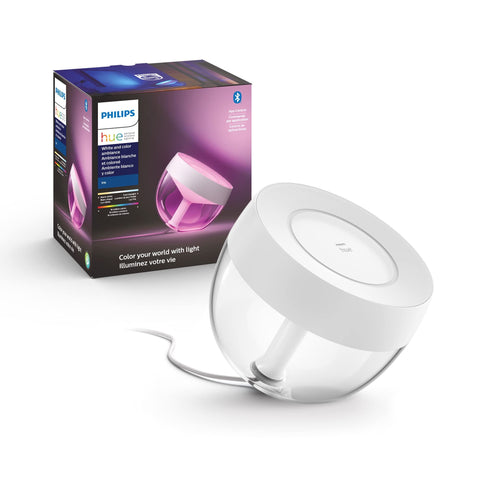 Philips Hue Iris lamp lit on a desk creates warm ambient light.
