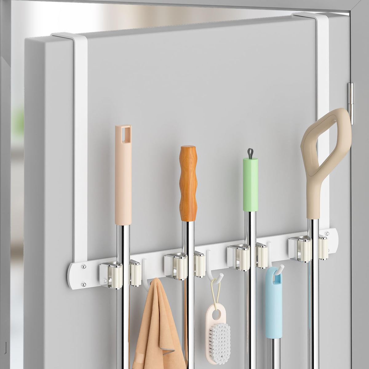 PrimZooty over-the-door broom holder keeps brooms organized behind the door.