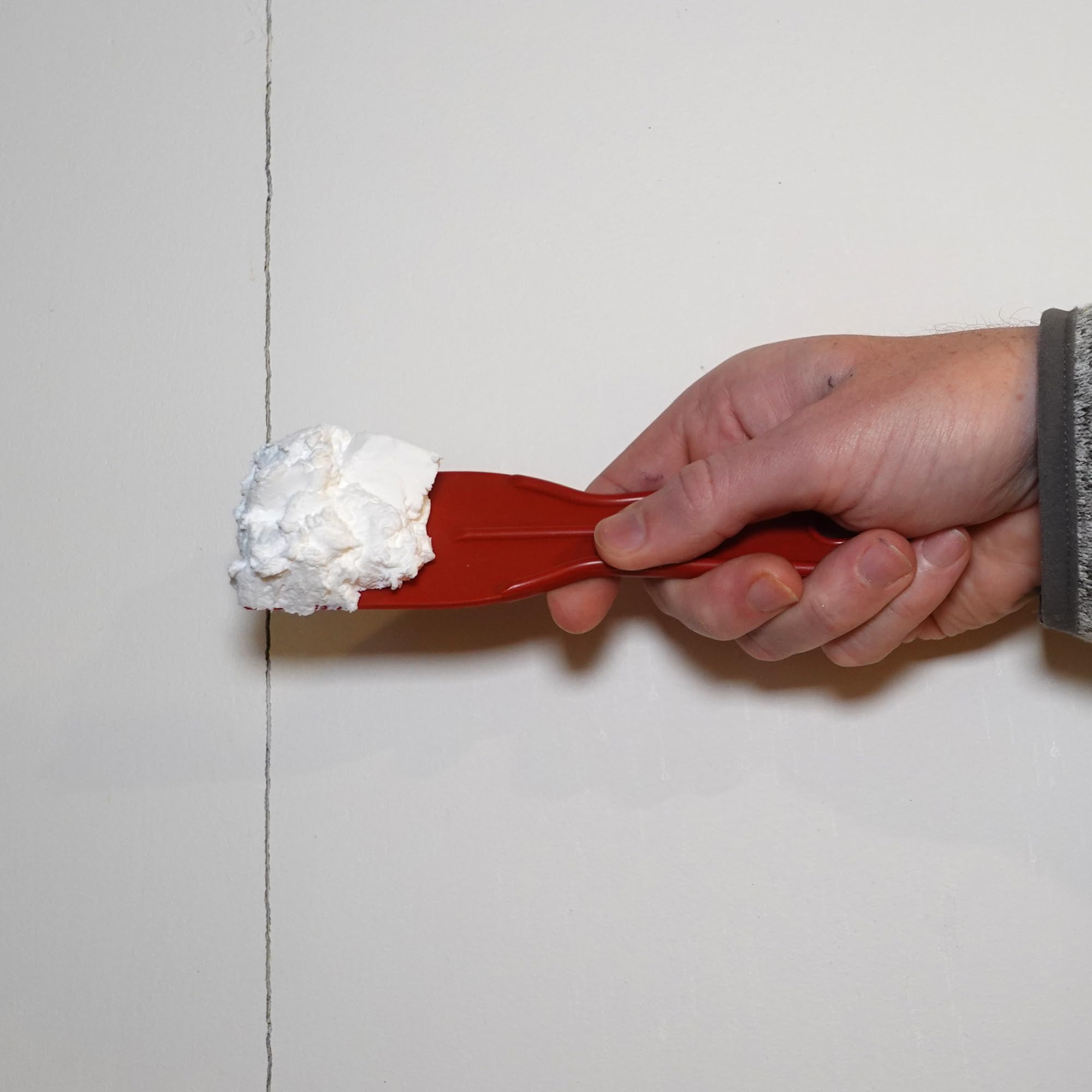 Smoothing Red Devil ONETIME spackle creates a seamless finish.