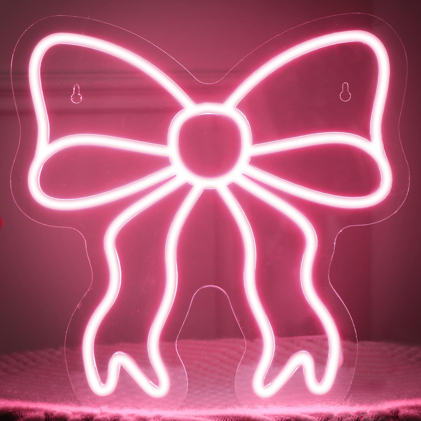 Retisee Pink Bow neon sign on wall with soft pink glow for chic decor.