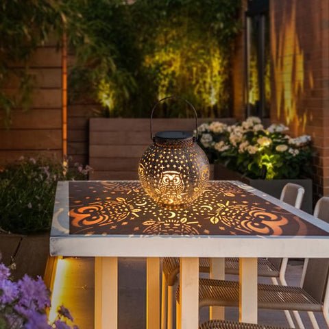 Singingarden Lantern on patio table provides warm ambient light.