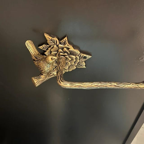 Stylentdecor brass bird toilet paper holder in a vintage bathroom scene.