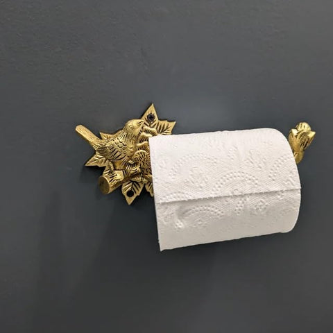 Stylentdecor brass bird toilet paper holder installed on wall with classic elegance.