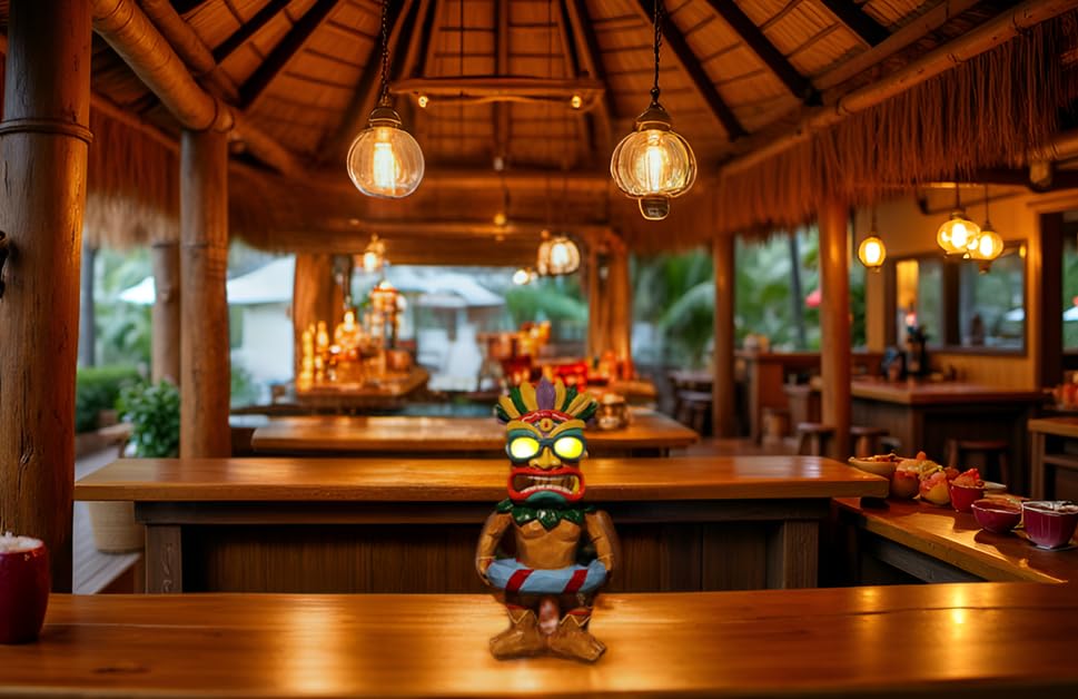Poolside night scene with SudsYard tiki statue illuminating water.