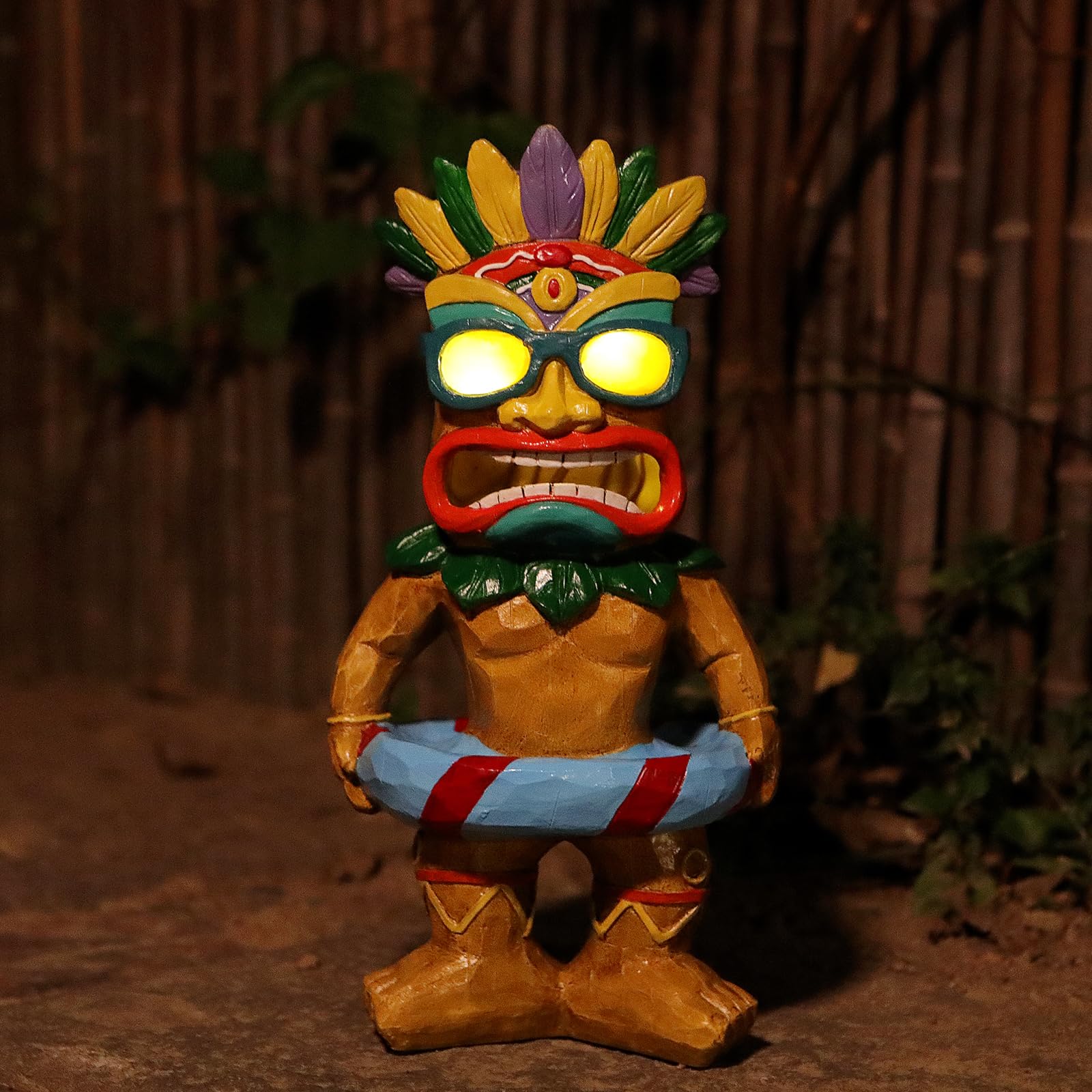 SudsYard Tiki swim ring statue glowing at night for poolside ambience.
