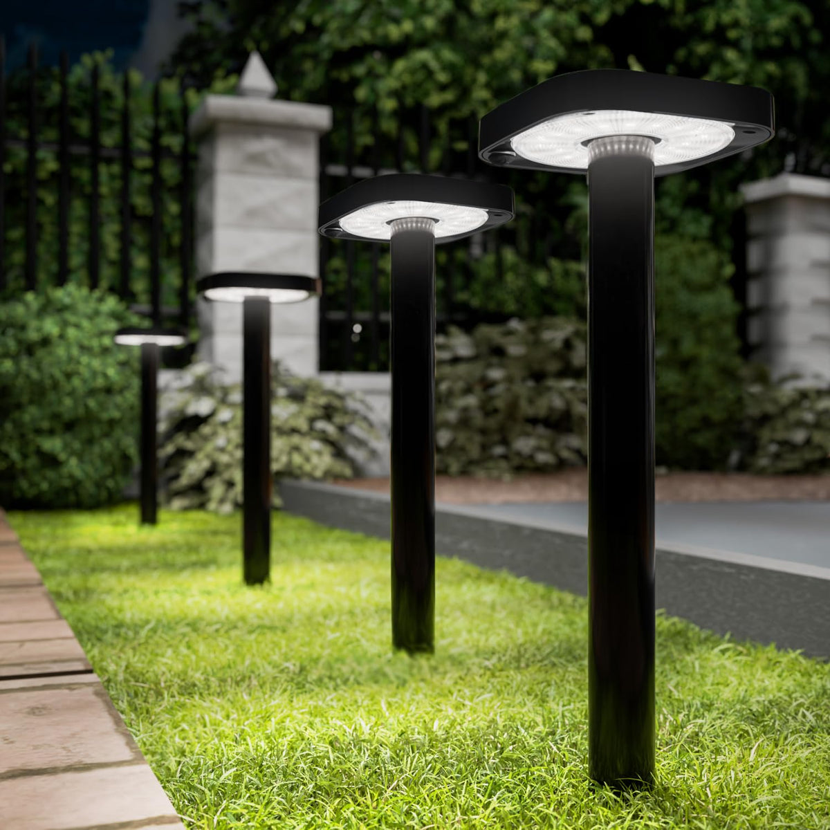 Sunco square solar pathway light front view glows softly along a garden path
