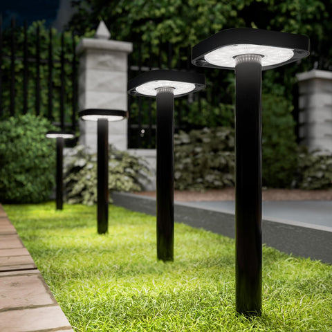 Sunco square solar pathway light front view glows softly along a garden path