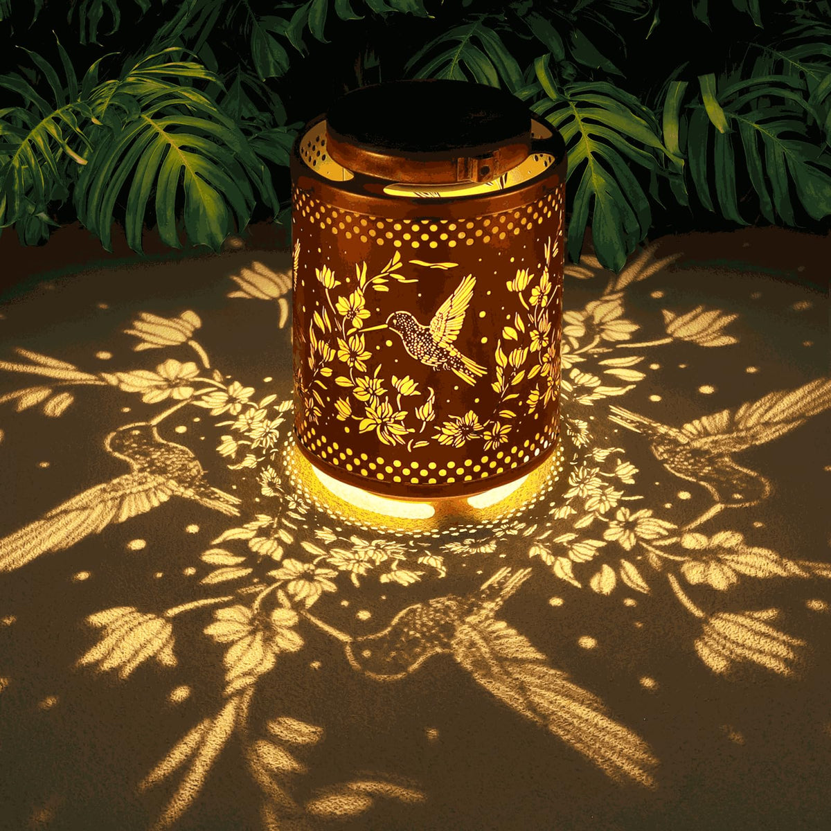 Tepaken hummingbird lantern in gold metal for ambient garden lighting.