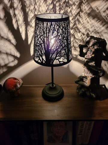 Timeflies forest-pattern shade casts decorative wall art for ambience.