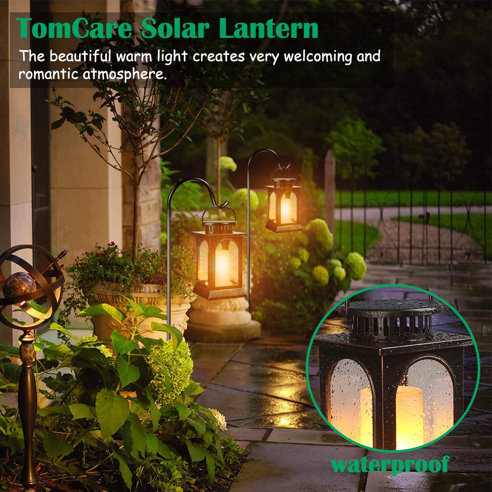 TomCare outdoor lantern illuminating a garden path with warm glow.