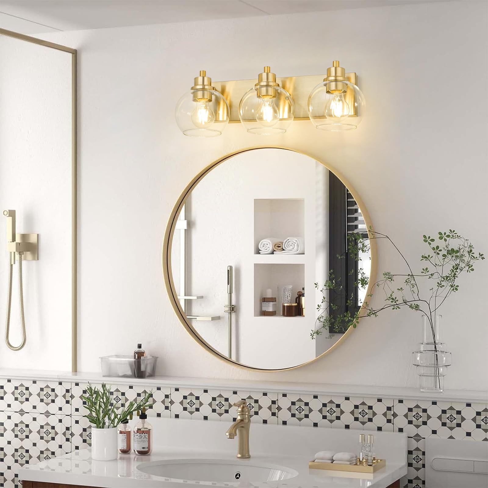 Tuscarora 3-light vanity sconce in brushed gold above mirror.