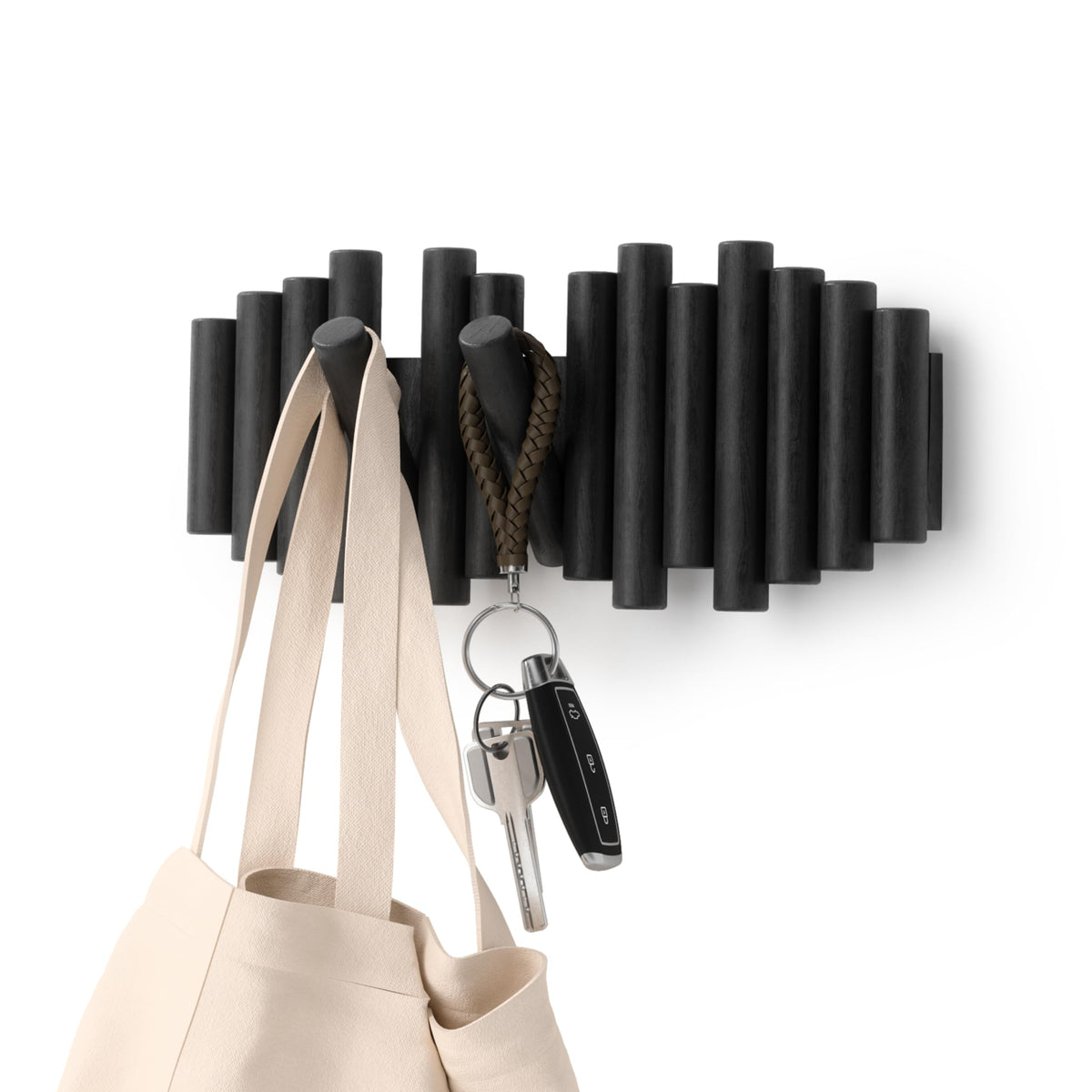Umbra Picket wall-mounted coat rack with five flip-down hooks for organized entryway storage.
