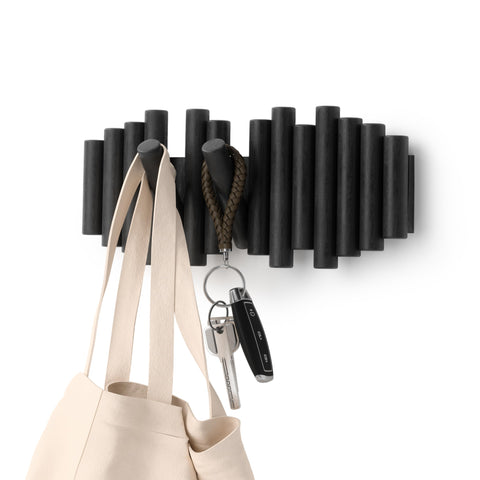 Umbra Picket wall-mounted coat rack with five flip-down hooks for organized entryway storage.