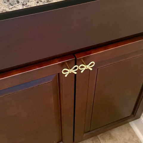 YEMCHI brass bow knob on a bookcase elevates interior design.