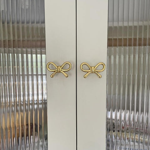 Beautiful gold bow knob adds character to wardrobe doors.