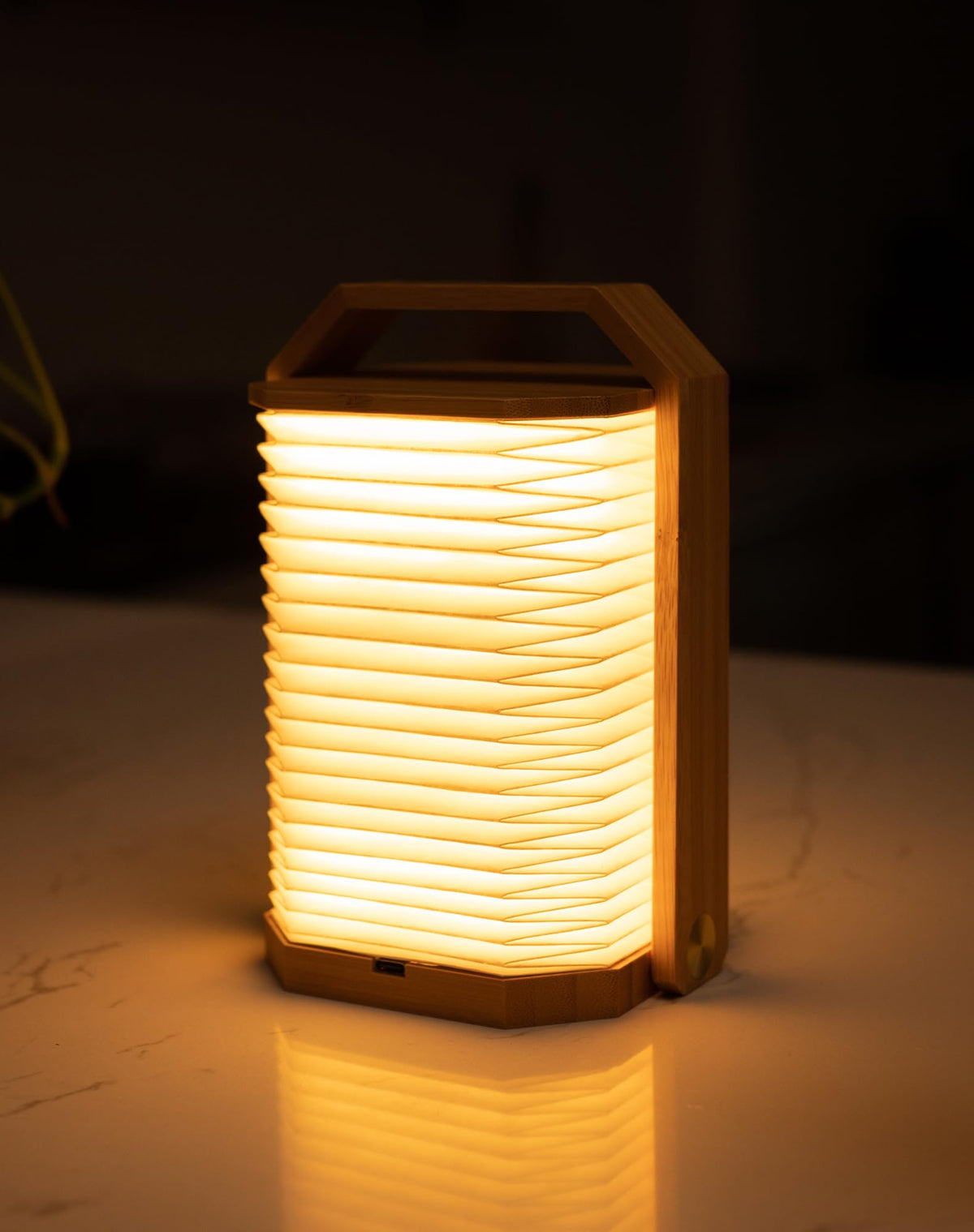 ZBOLE Portable Bamboo Lamp folded in hand, showcasing compact travel-friendly design.